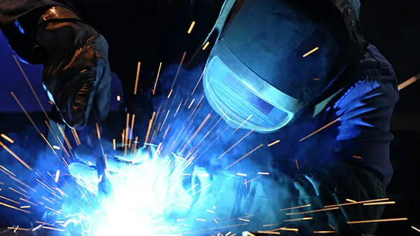 Welder working on stainless steel sanitary process piping